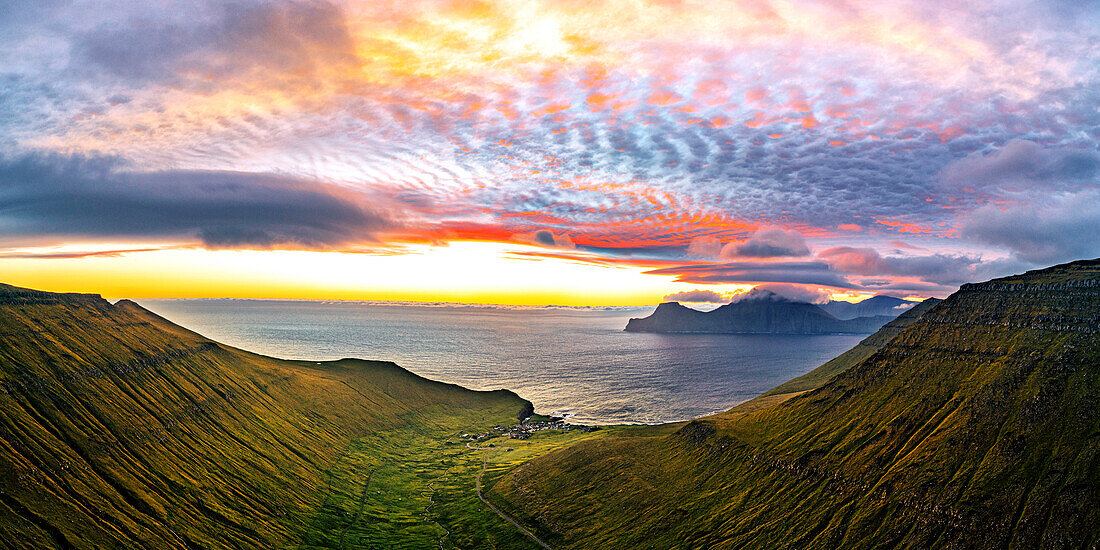 Dramatischer Himmel mit Wolken bei Sonnenaufgang über dem Küstendorf Gjogv, Luftbild, Eysturoy Island, Färöer Inseln, Dänemark, Europa