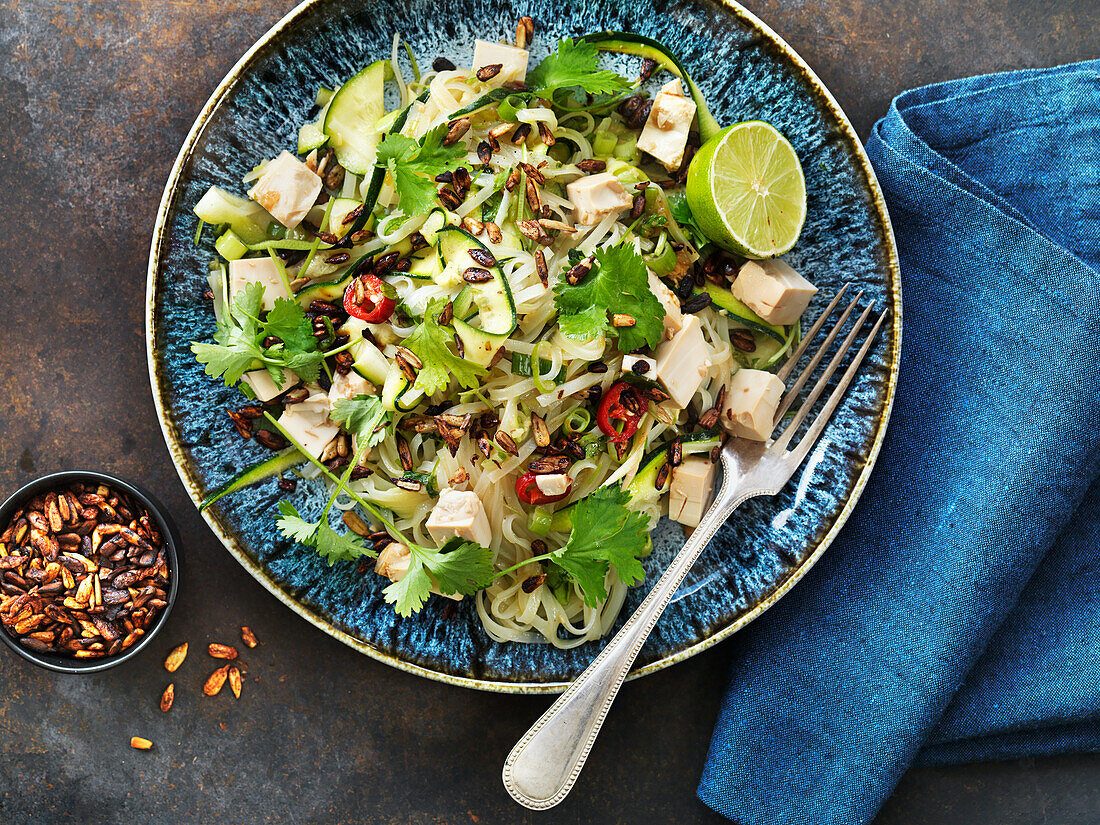 Pasta salad with tofu, lime, zucchini, cilantro, and roasted sunflower seeds