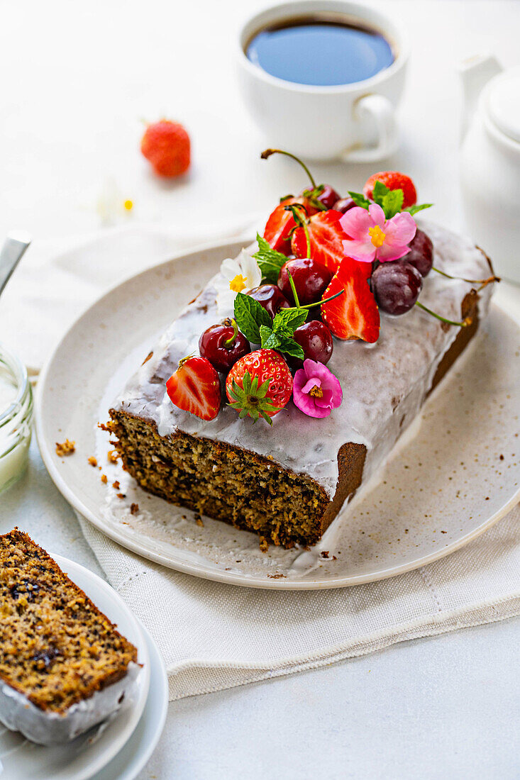 Pound cake with frosting, fresh strawberries, and cherries