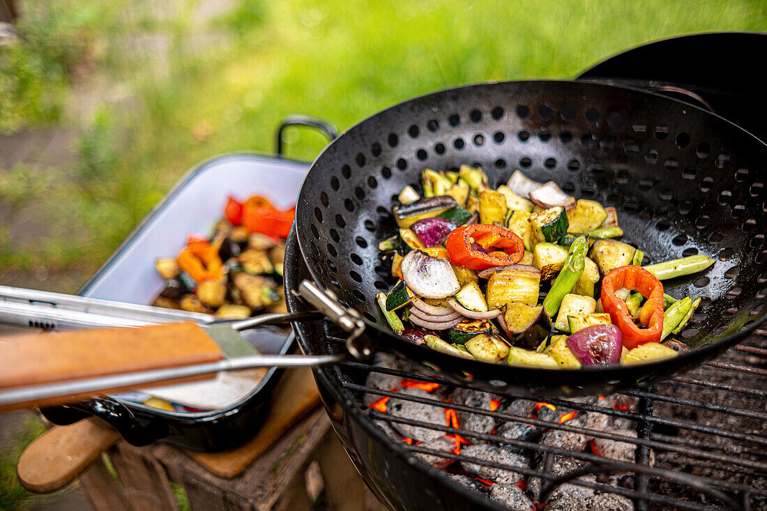 Gemüse in einer Pfanne auf Holzkohlegrill