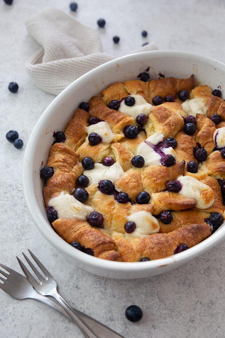 Breakfast casserole of croissants with blueberries and vegan 'cream cheese' blobs