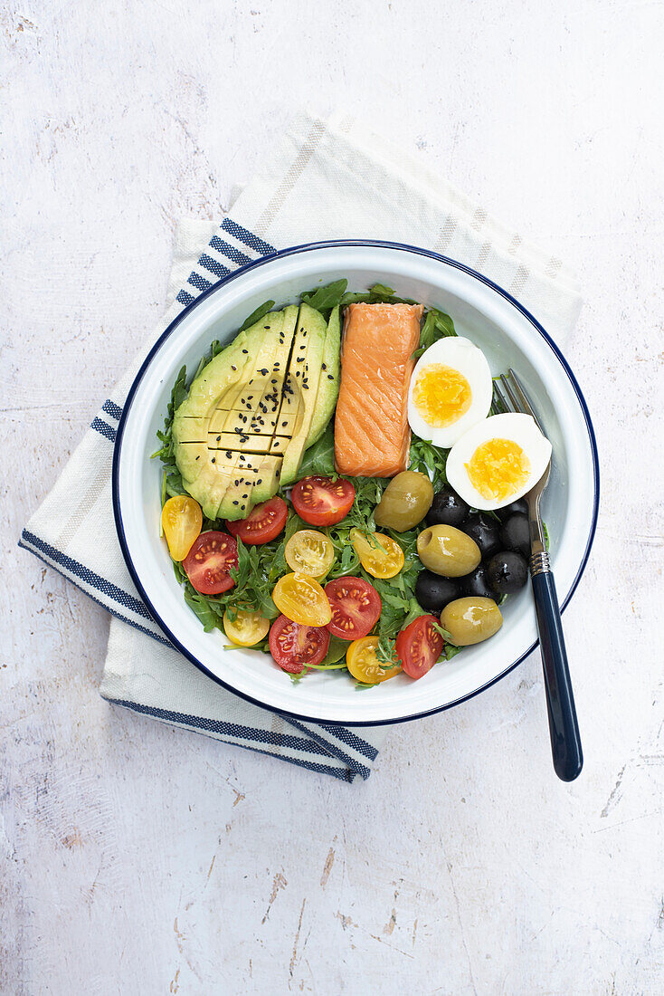 Keto-Frühstück mit Räucherlachs, gekochtes Ei, Avocado, Oliven, Rucola und Tomaten