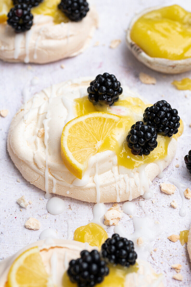 Mini meringues topped with lemon curd and blackberries