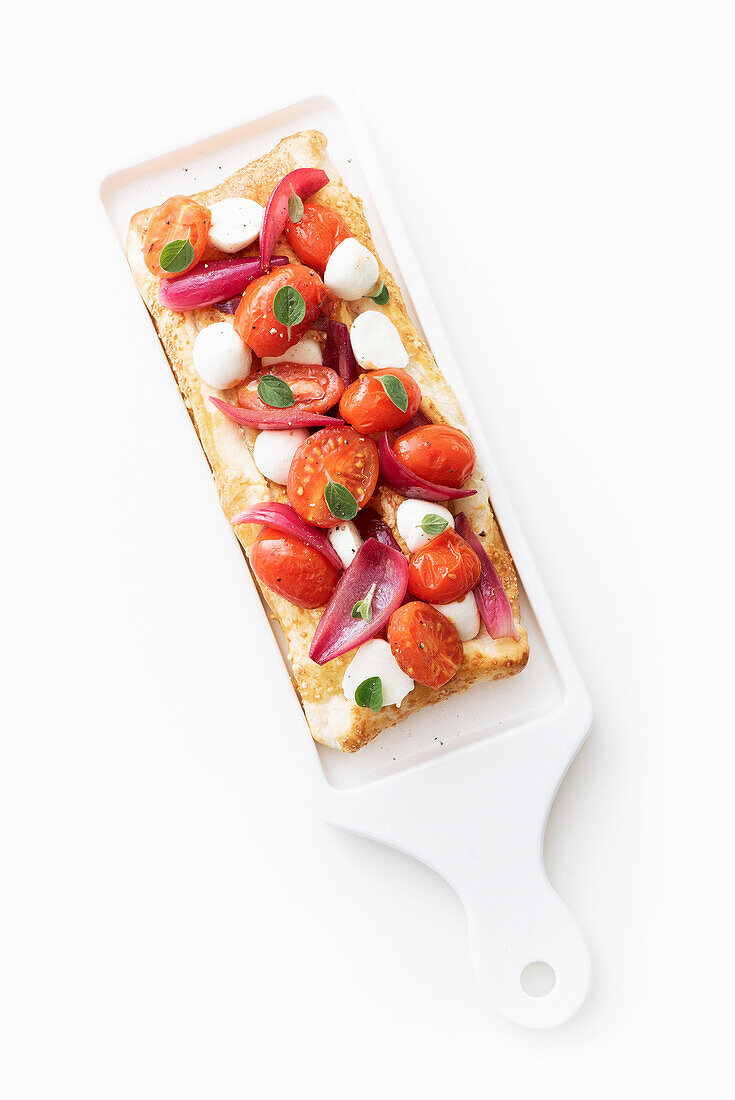 Puff pastry with mozzarella balls, cherry tomatoes and red onions