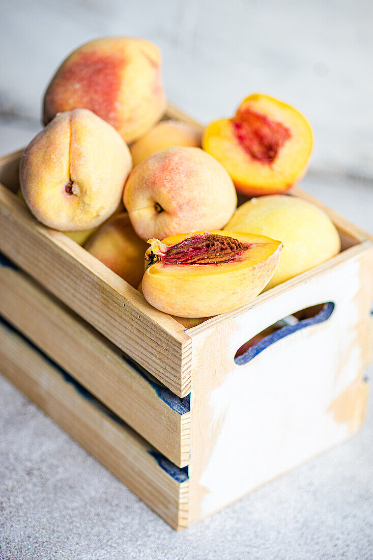 Wooden box with ripe organic peaches
