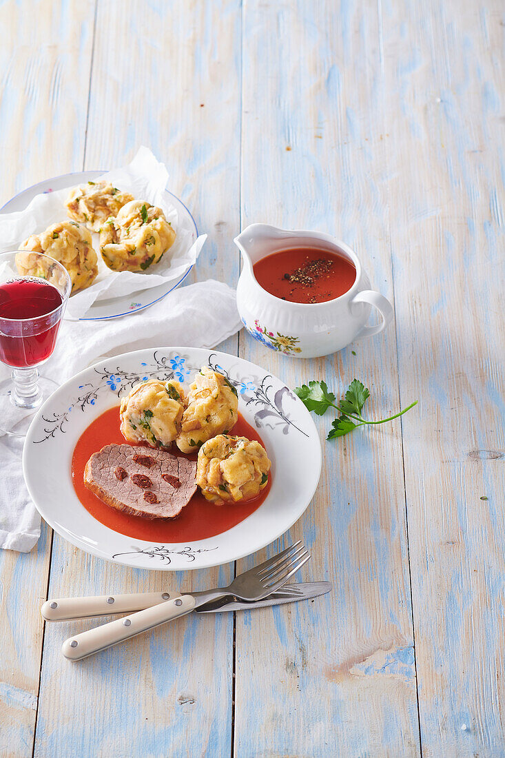 Roast beef with dumplings and tomato sauce