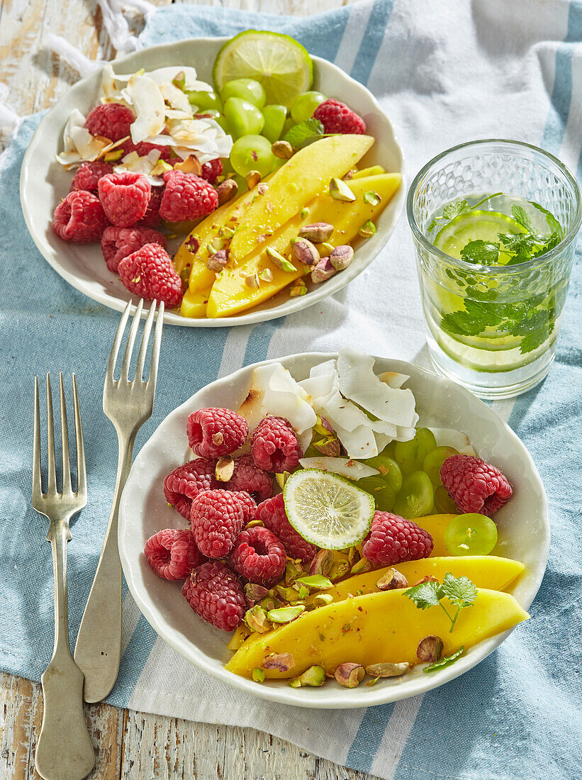 Fruchtsalat mit Mango, Himbeeren, Weintrauben und Joghurt