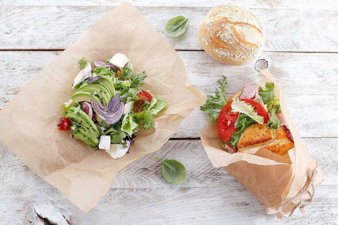 Sandwich and salad wrapped in paper