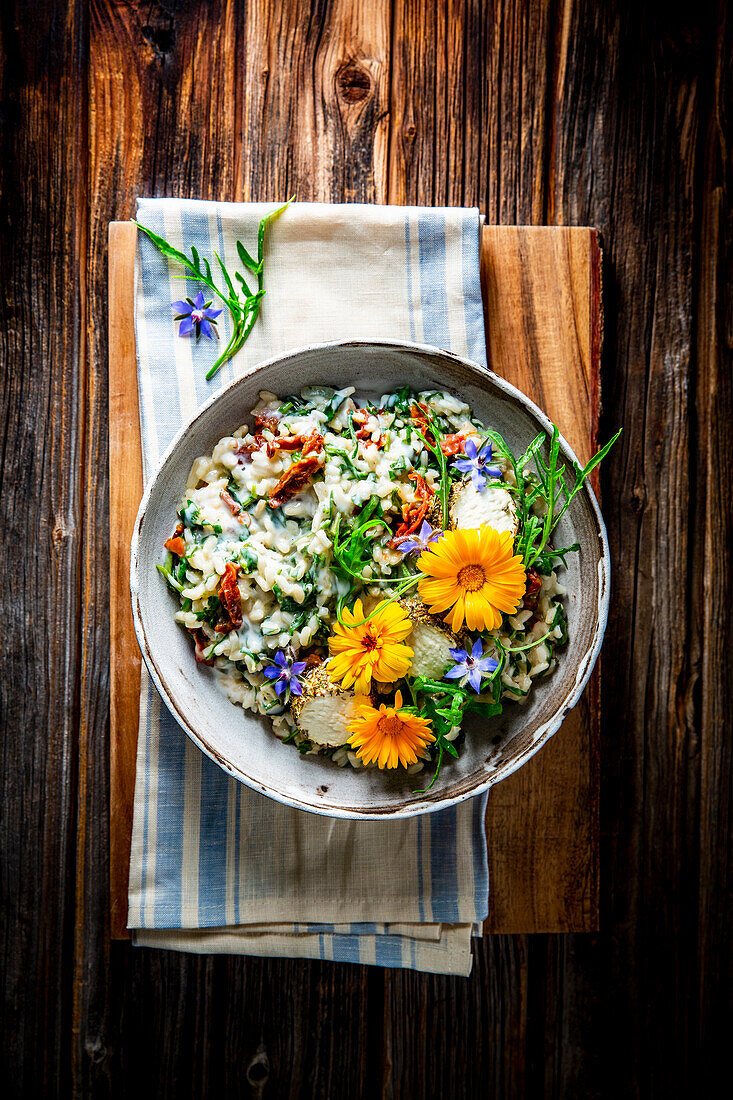 Arugula white wine risotto with edible flowers