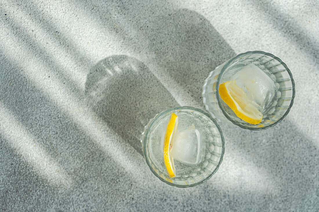 Vodka tonic served with lemon and ice cubes