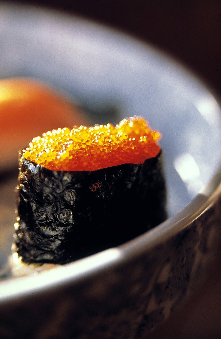 Ein Sushi-Röllchen mit rotem Kaviar & Noriblatt