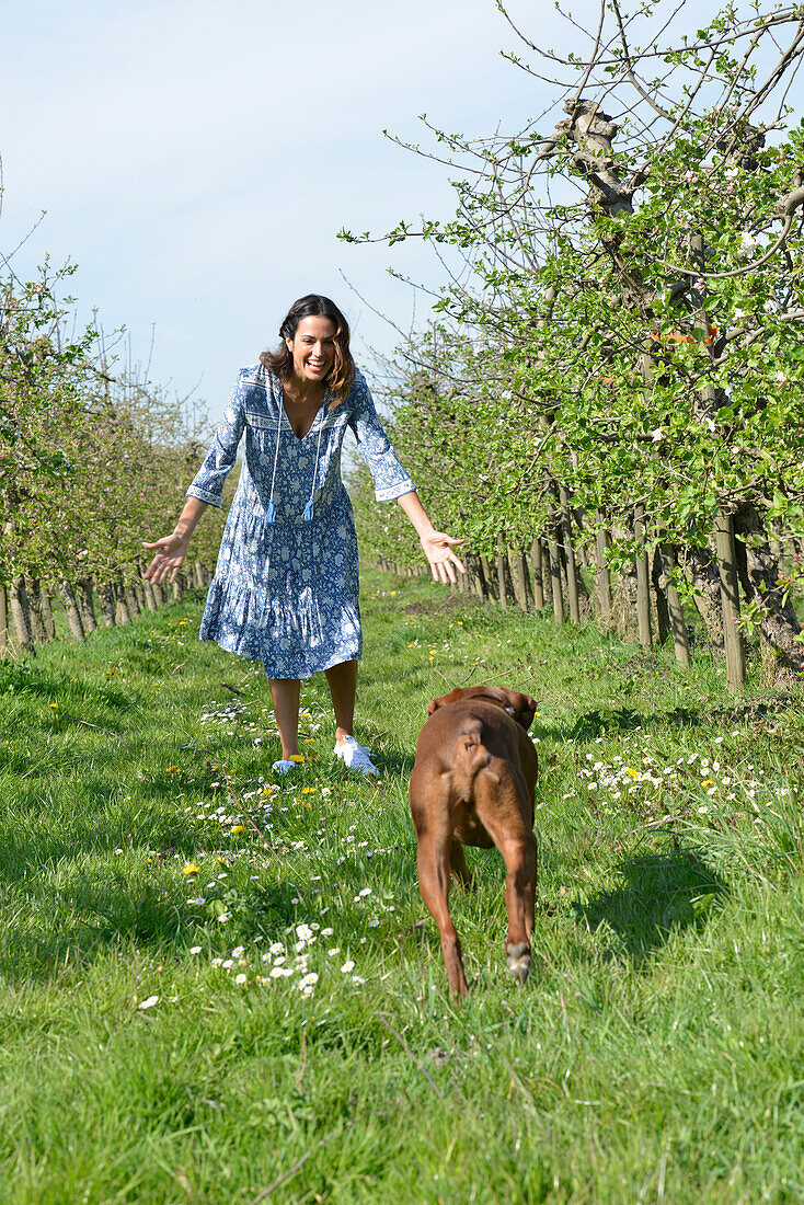 Brünette Frau mit Hund im Garten