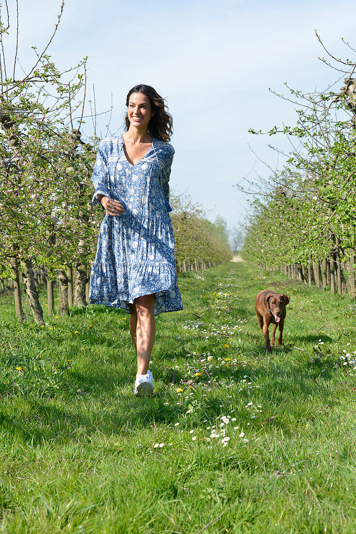 Brünette Frau mit Hund im Garten