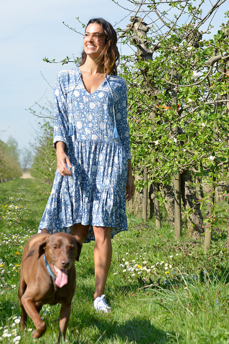 Brünette Frau mit Hund im Garten