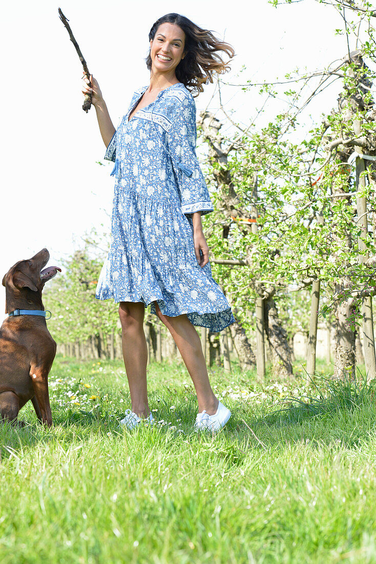 Brünette Frau mit Hund im Garten