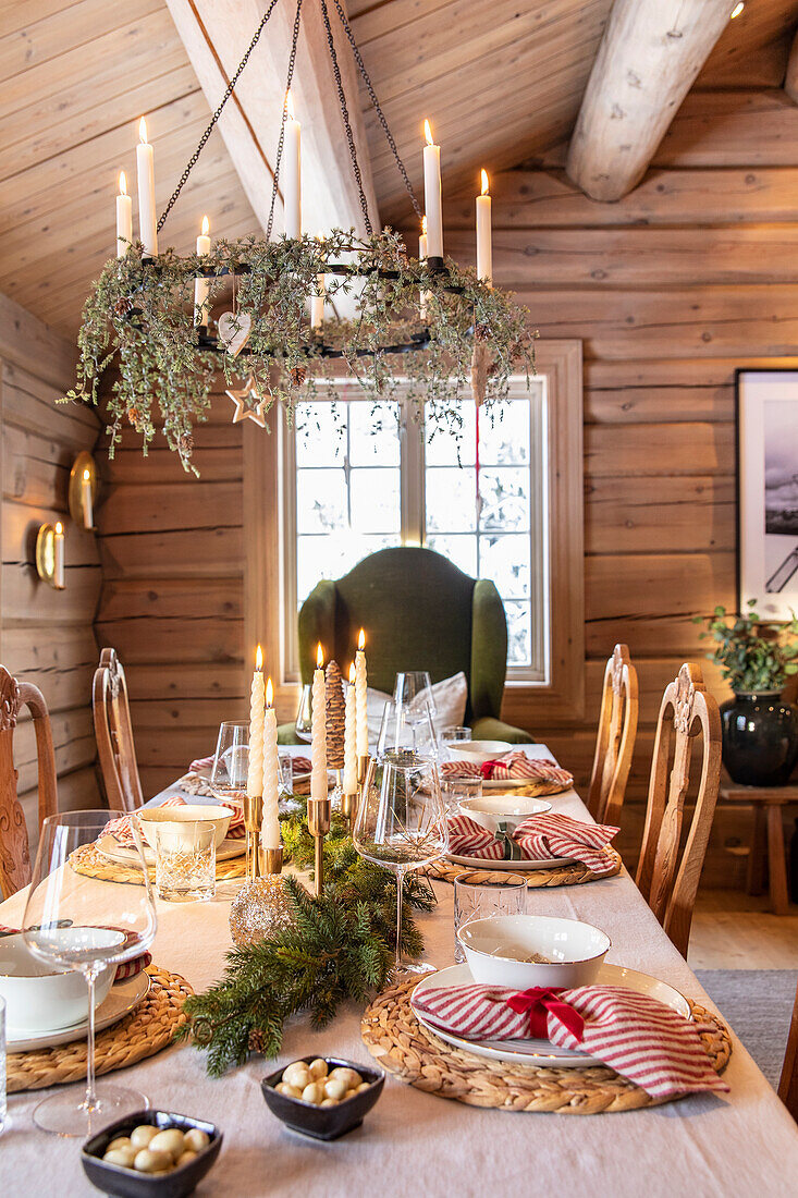 Rustikal gedeckter Esstisch mit Weihnachtsdeko, Kronleuchter und Naturmaterialien