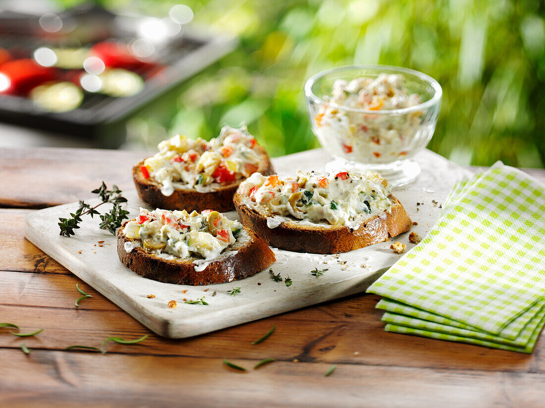 Onion baguette with herb cream cheese, zucchini, and olives