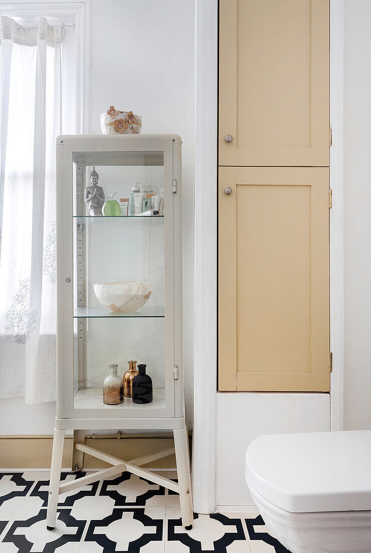 Bathroom with white display cabinet and patterned tiled floor