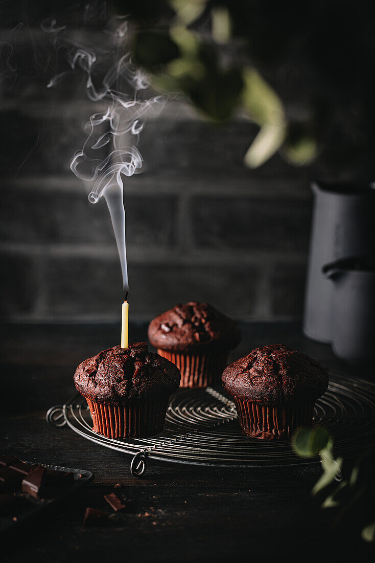 Schokoladenmuffins mit Schokostückchen und mit Kerze