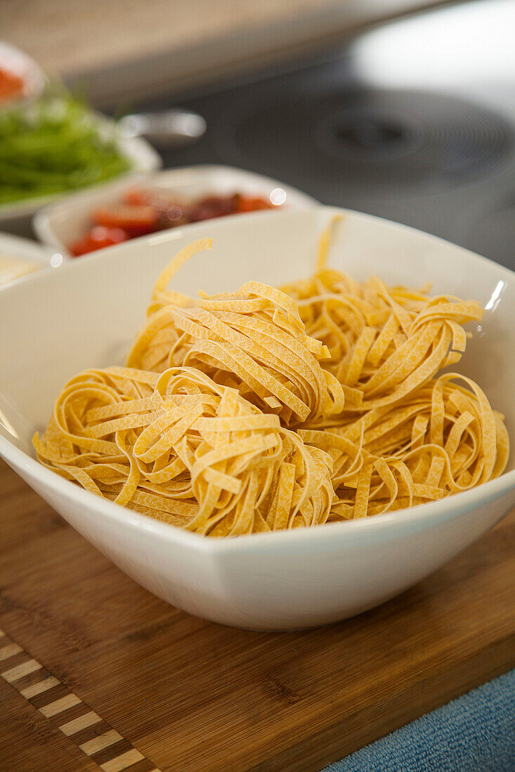 Fresh ribbon noodles in a white bowl