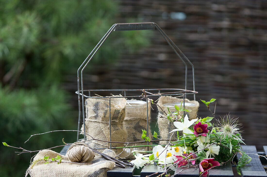 DIY-Vasen aus Weckgläsern und Sackstoff im Flaschenkorb und Frühlingsblumenstrauß