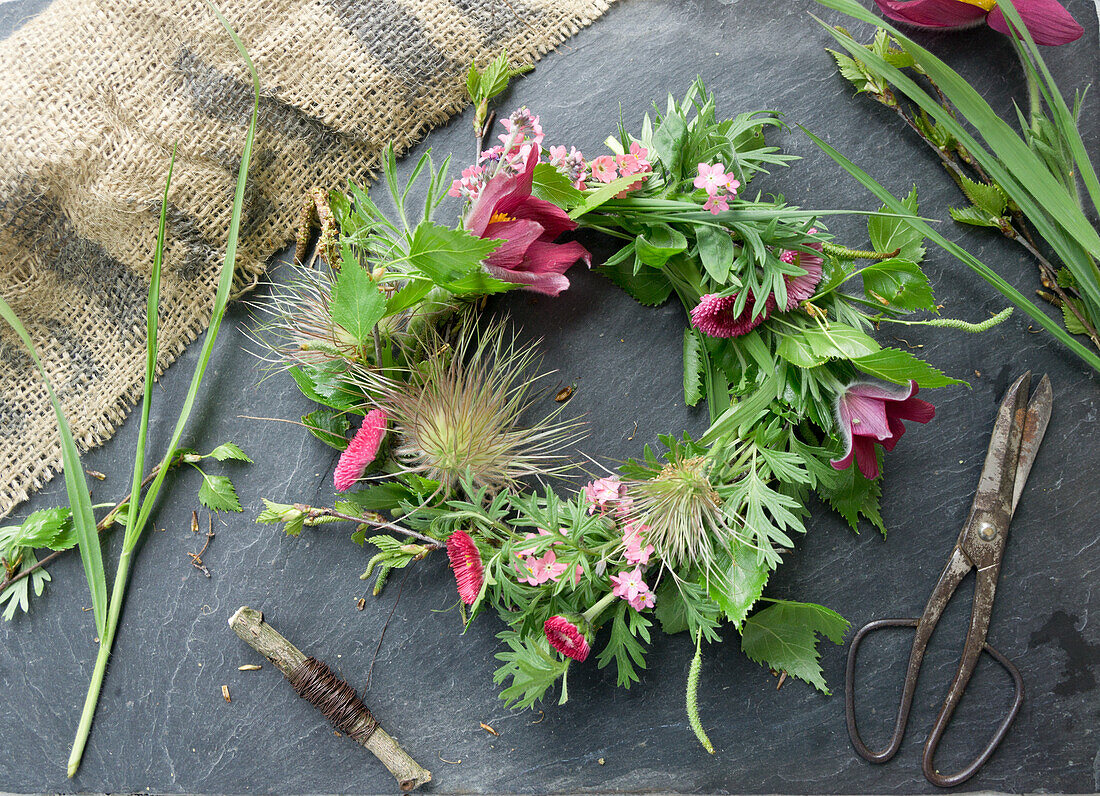 Wreath made of pasque flower (Pulsatilla), forget-me-not, daisies (Bellis) and birch twigs