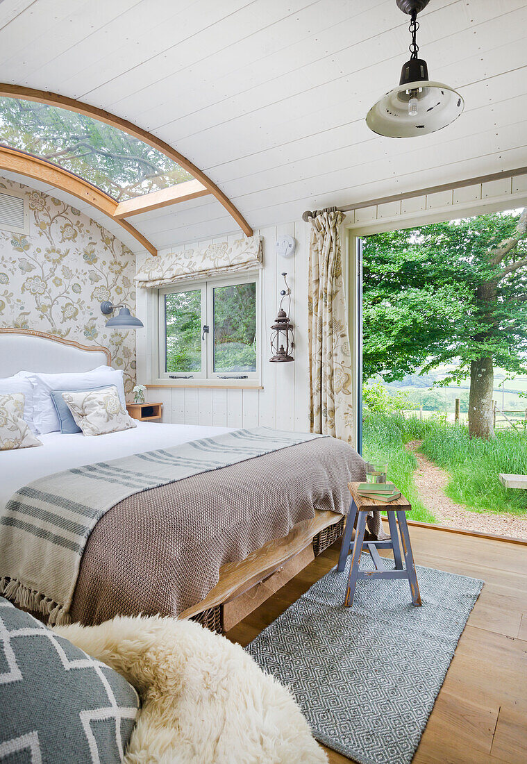 Bedroom with skylight, curved wooden ceiling and view of the countryside