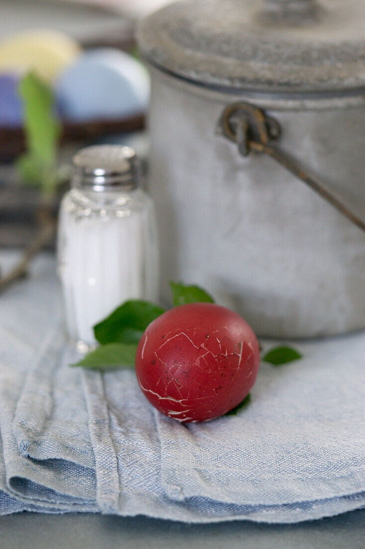 Red Easter egg with broken shell and salt shaker