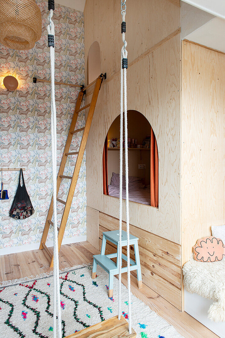 Children's room with loft bed made of light-colored wood and a swing