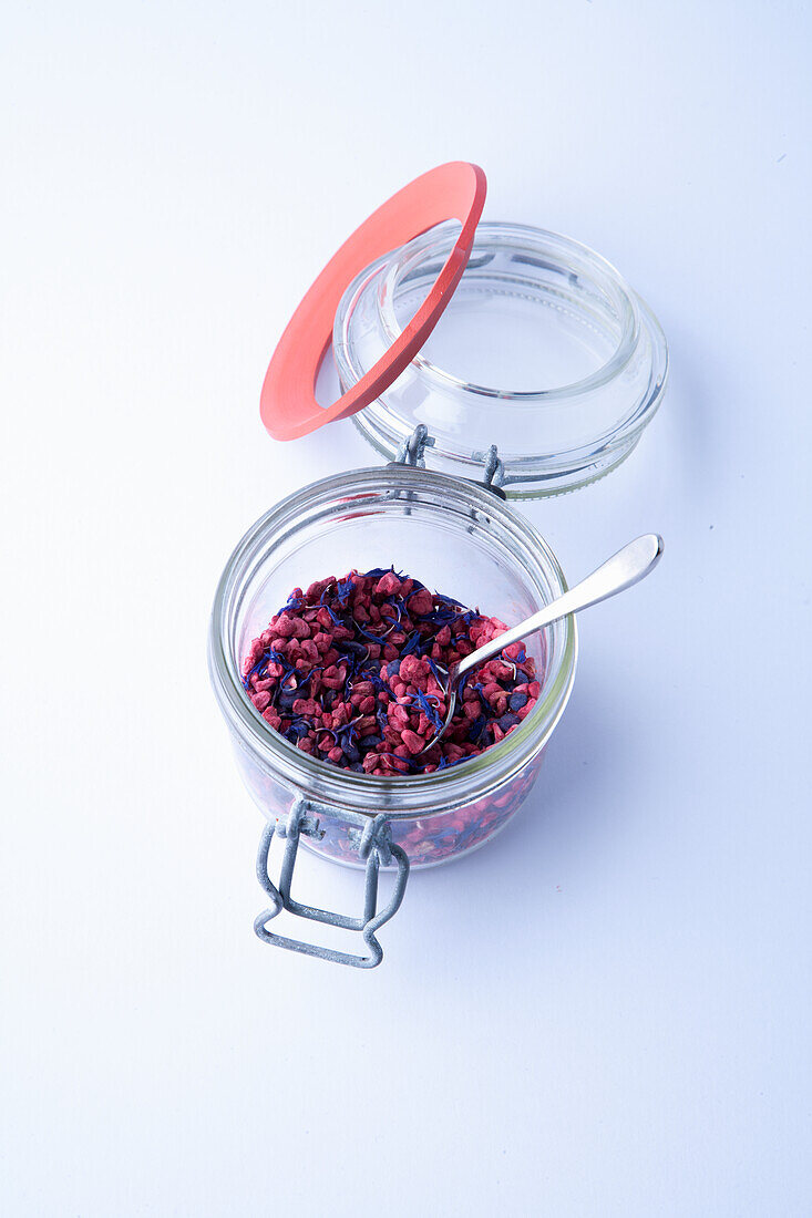 Borage flowers and freeze-dried red berries in a jar