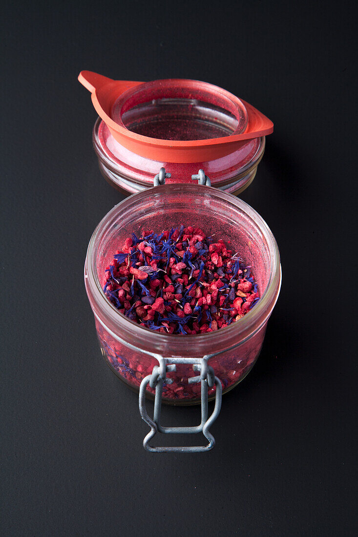 Borage flowers and freeze-dried red berries in a jar