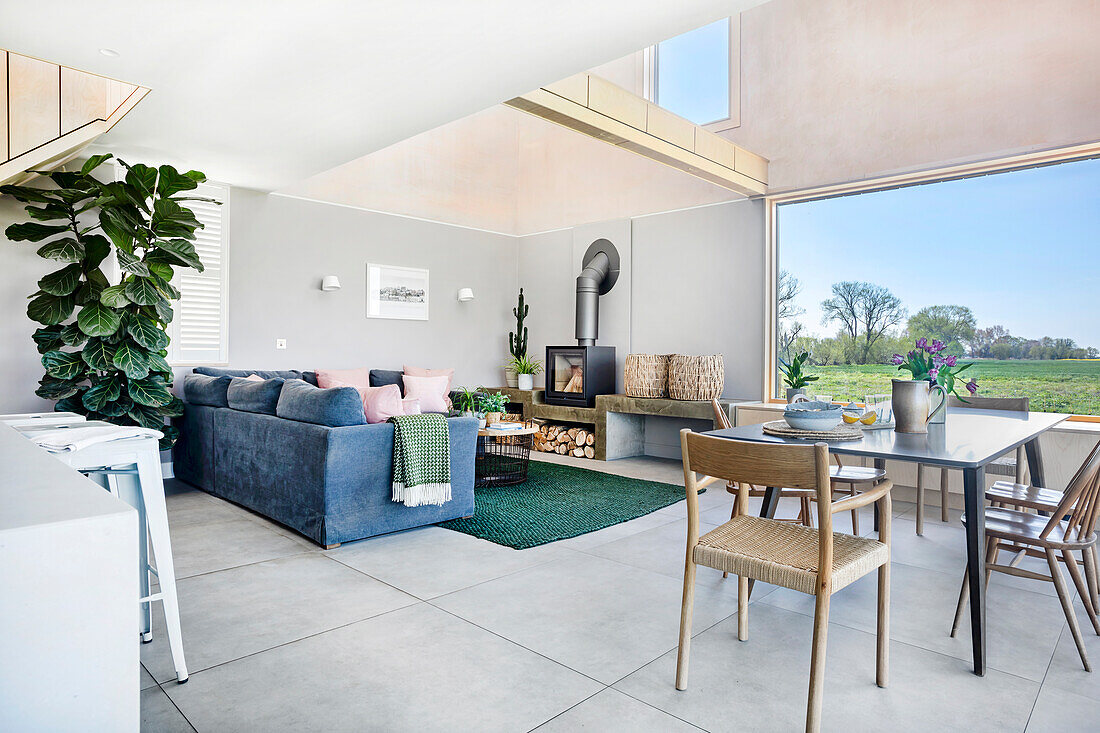 Open-plan living dining area with fireplace and panoramic windows, view of the countryside