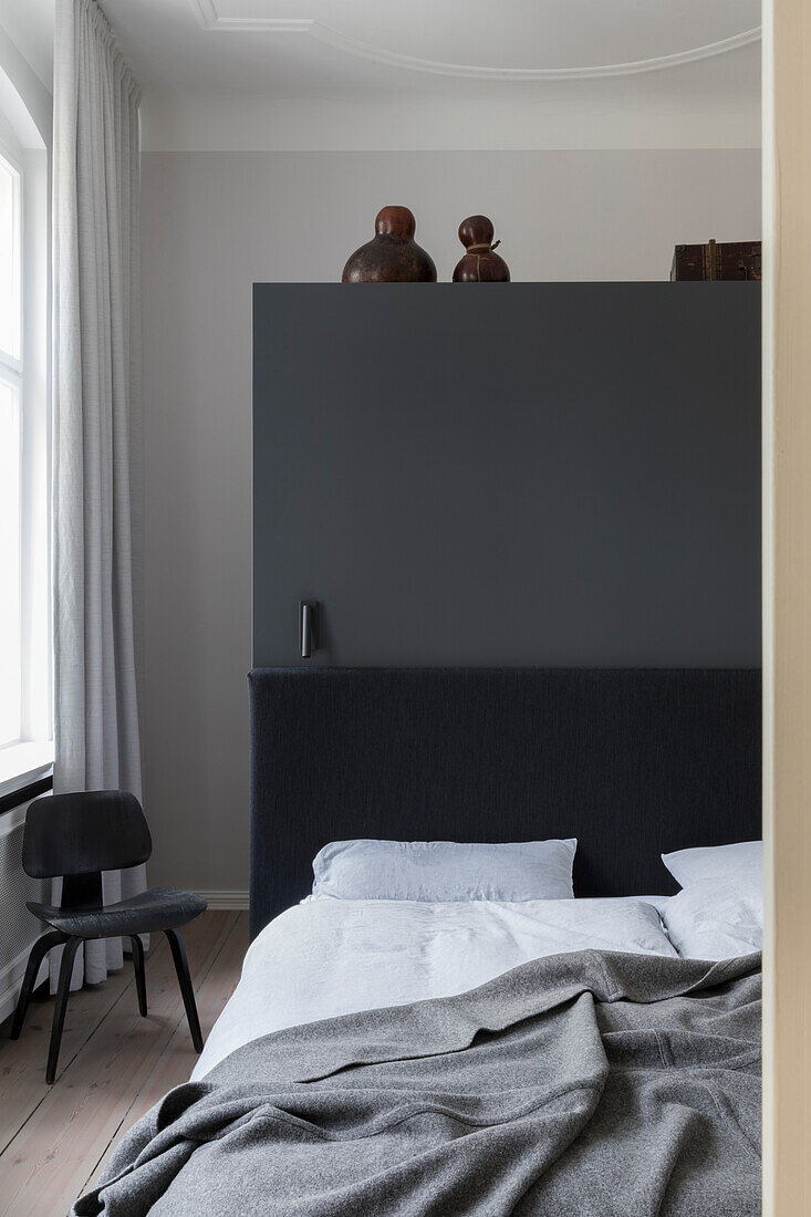 Modern bedroom with dark grey accent wall and light wooden flooring