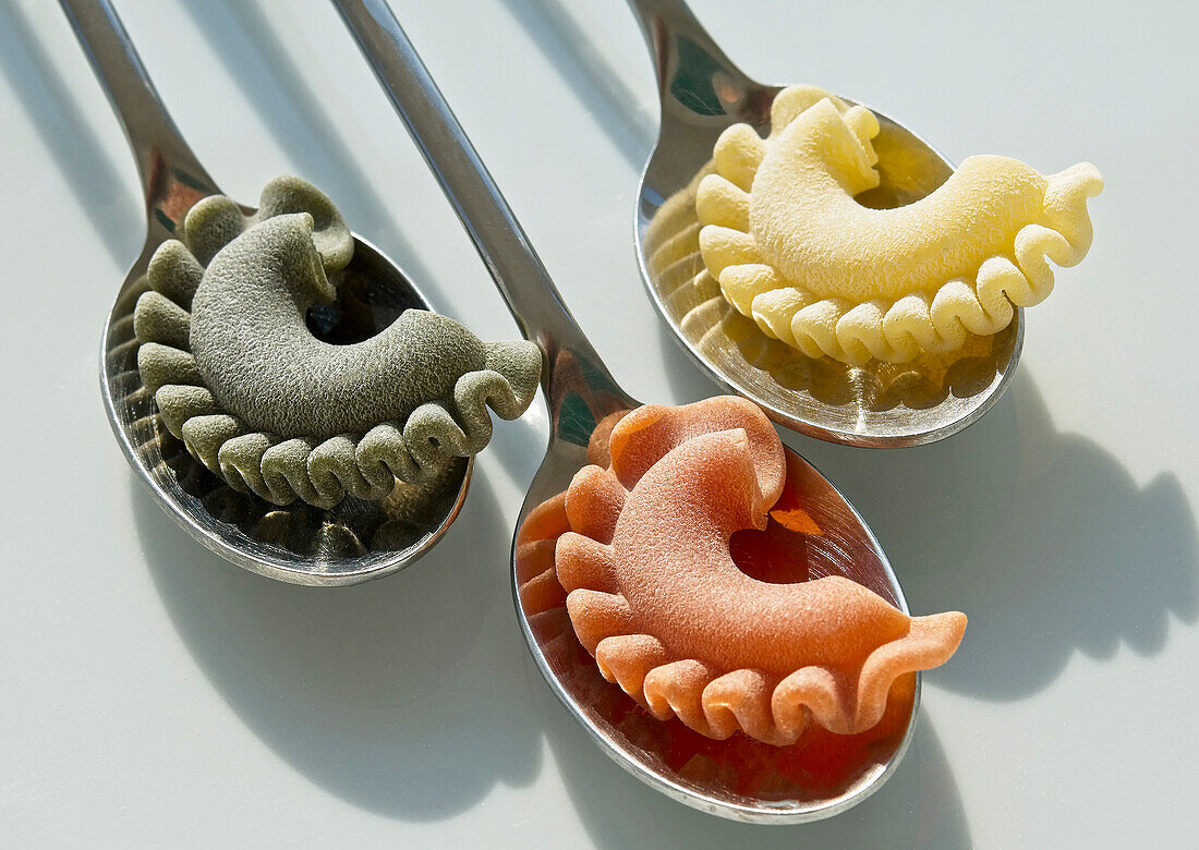 Colourful pasta on spoons