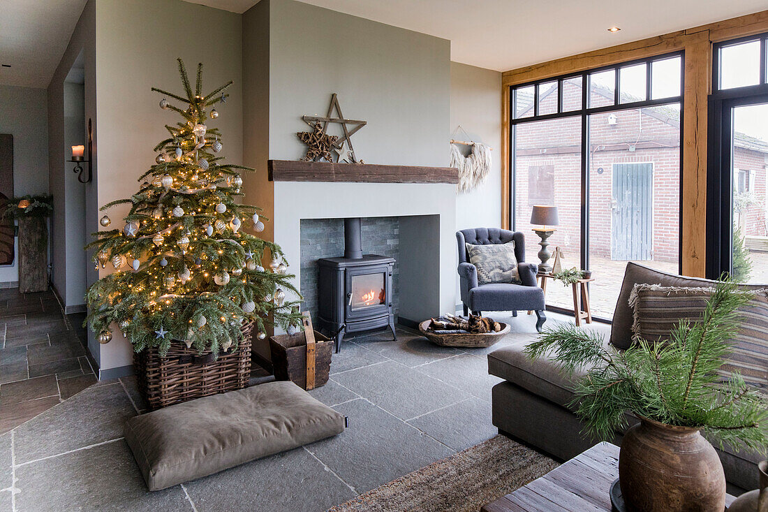 Wohnzimmer mit bodentiefen Fenstern, Kaminofen und Weihnachtsbaum