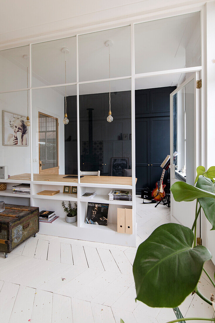 Music room with glass wall, built-in desk and white floorboards