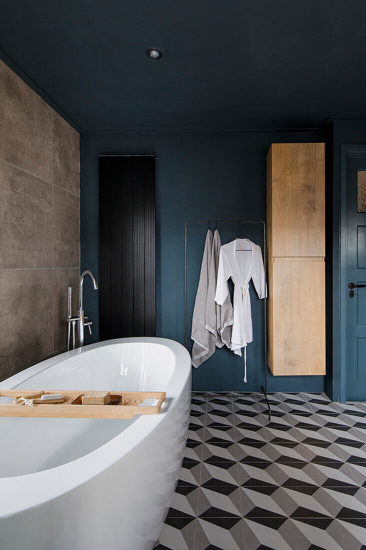 Modernes Badezimmer mit petrolfarbenen Wänden, freistehender Wanne und geometrischem Fliesenmuster