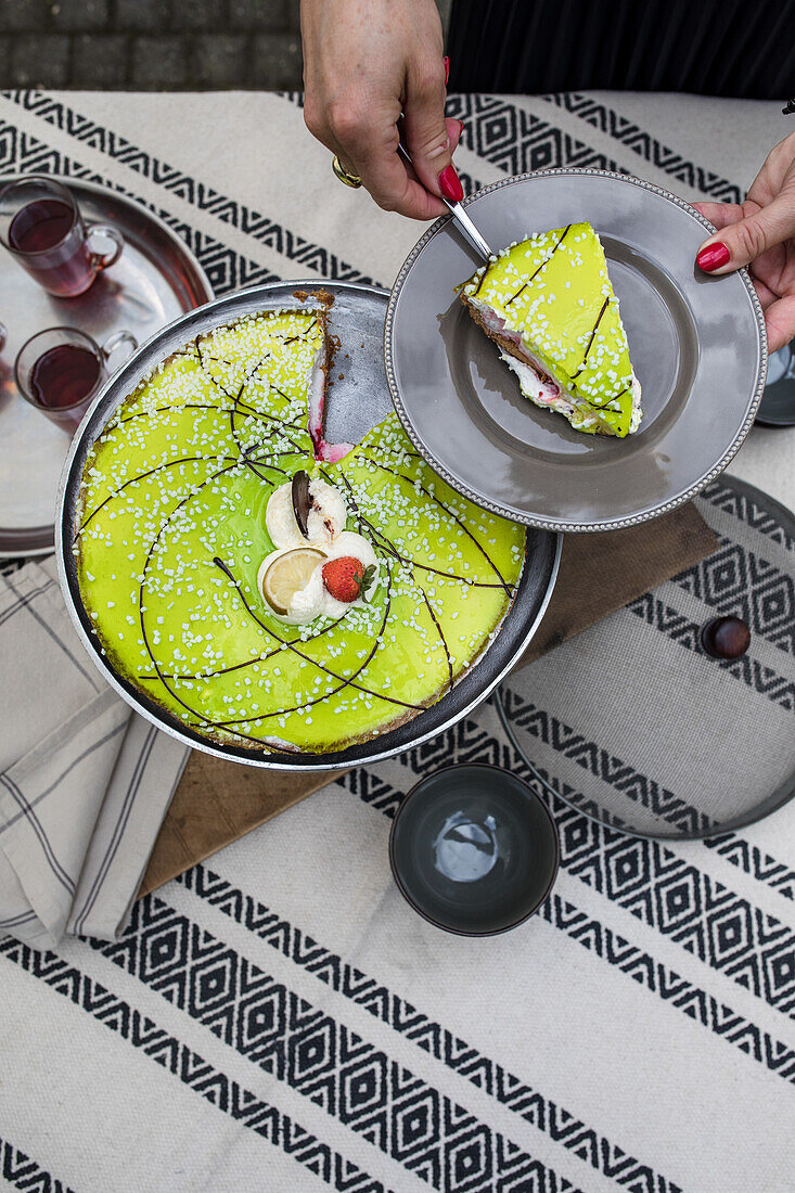 Aufgeschnittene Avocado-Limetten-Torte auf grauem Teller