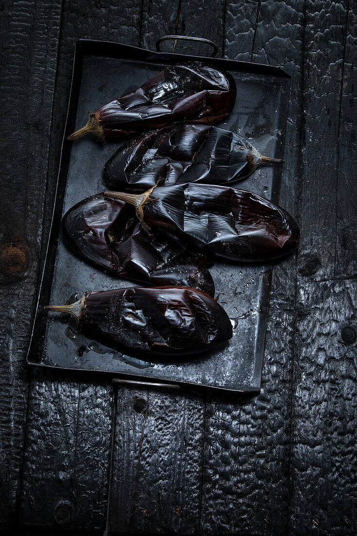 Grilled aubergine on a black baking tray