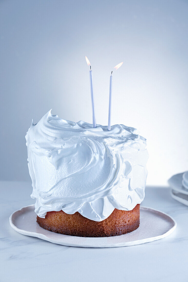 Chocolate and nut cake with whipped cream topping and two candles