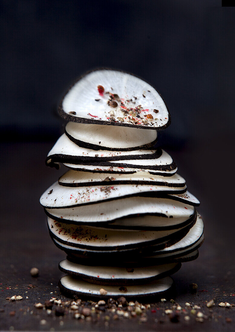 Sliced black radish stacked with spices
