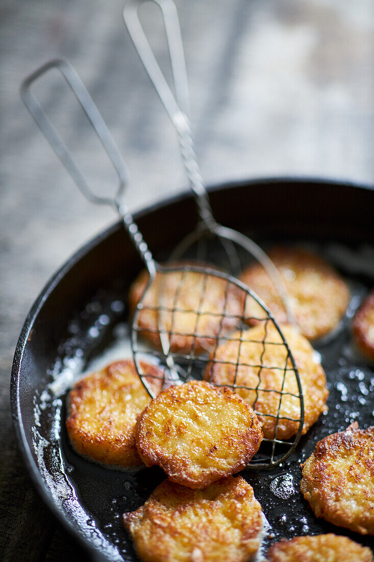 Frying small potato rostis