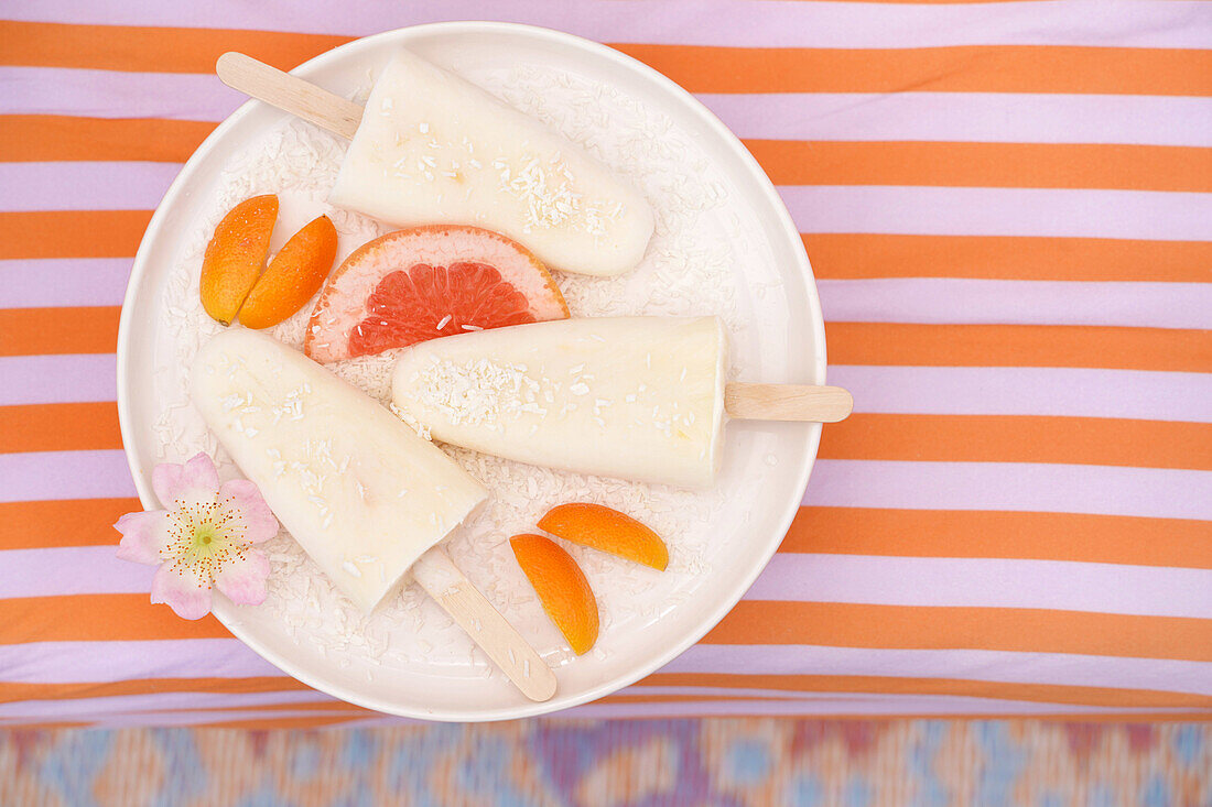 Homemade ice pops on a plate with grapefruit and apricot slices