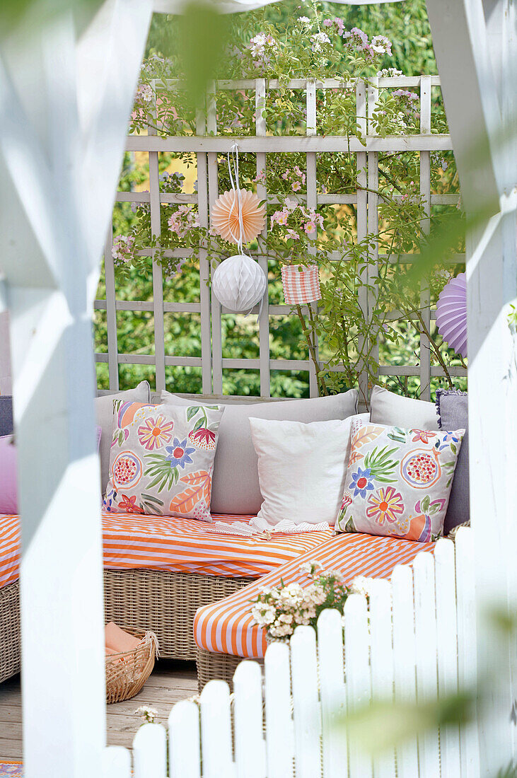 Cozy seating area on the terrace with rattan sofa and colorful cushions