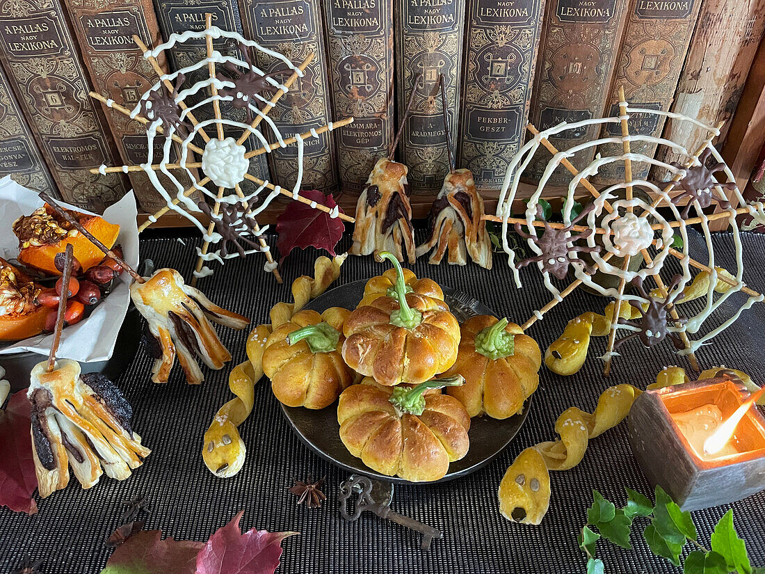 Gefüllte Mini-Kürbiskuchen, Salzstangen in Schlangenform und Schoko-Besen und Spinnennetz zu Halloween