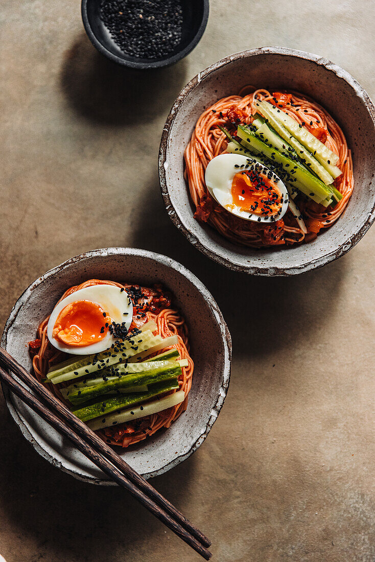 Cold Korean wheat noodles with soft-boiled egg in a spicy marinade made from gochujang paste