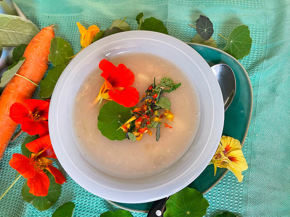 Cream of vegetable soup with nasturtium flowers