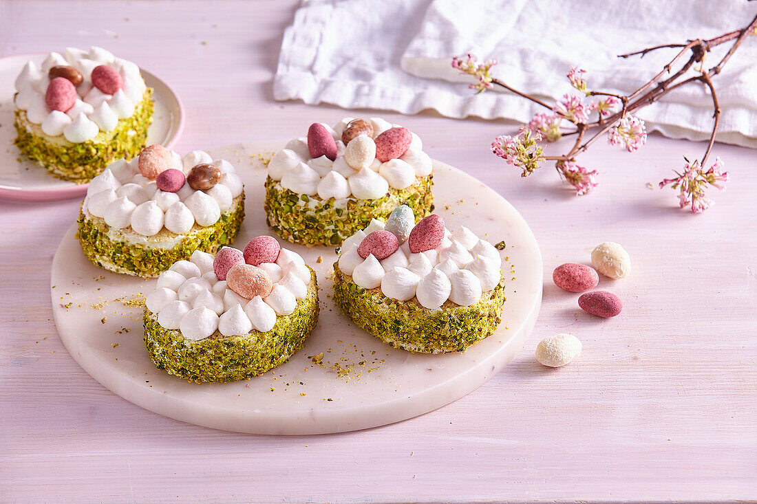 Egg-shaped Easter cakes with pistachios and cream