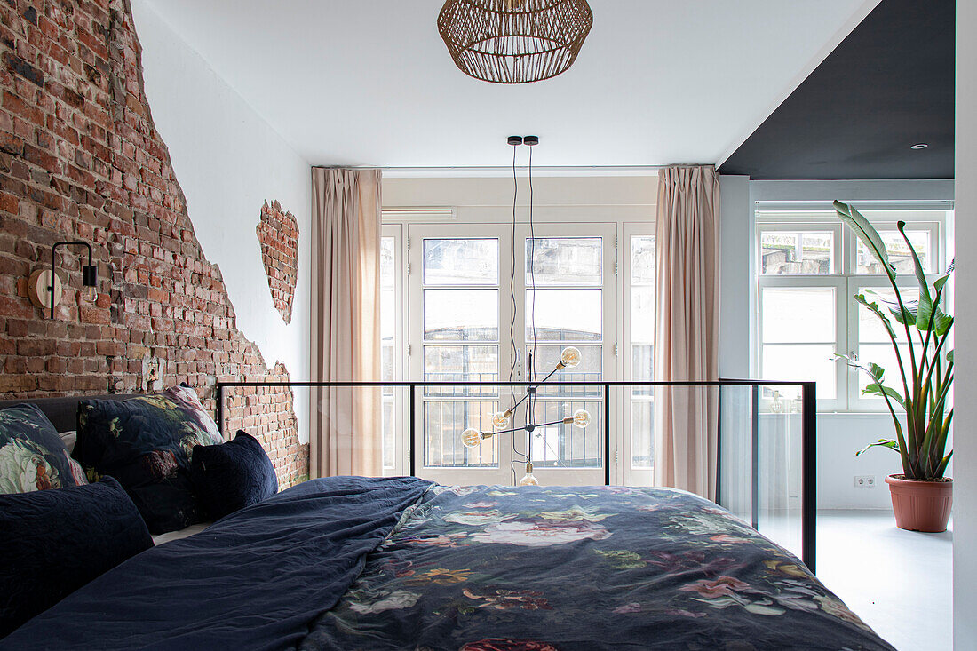 Bedroom with brick wall, pendant lamp and windows