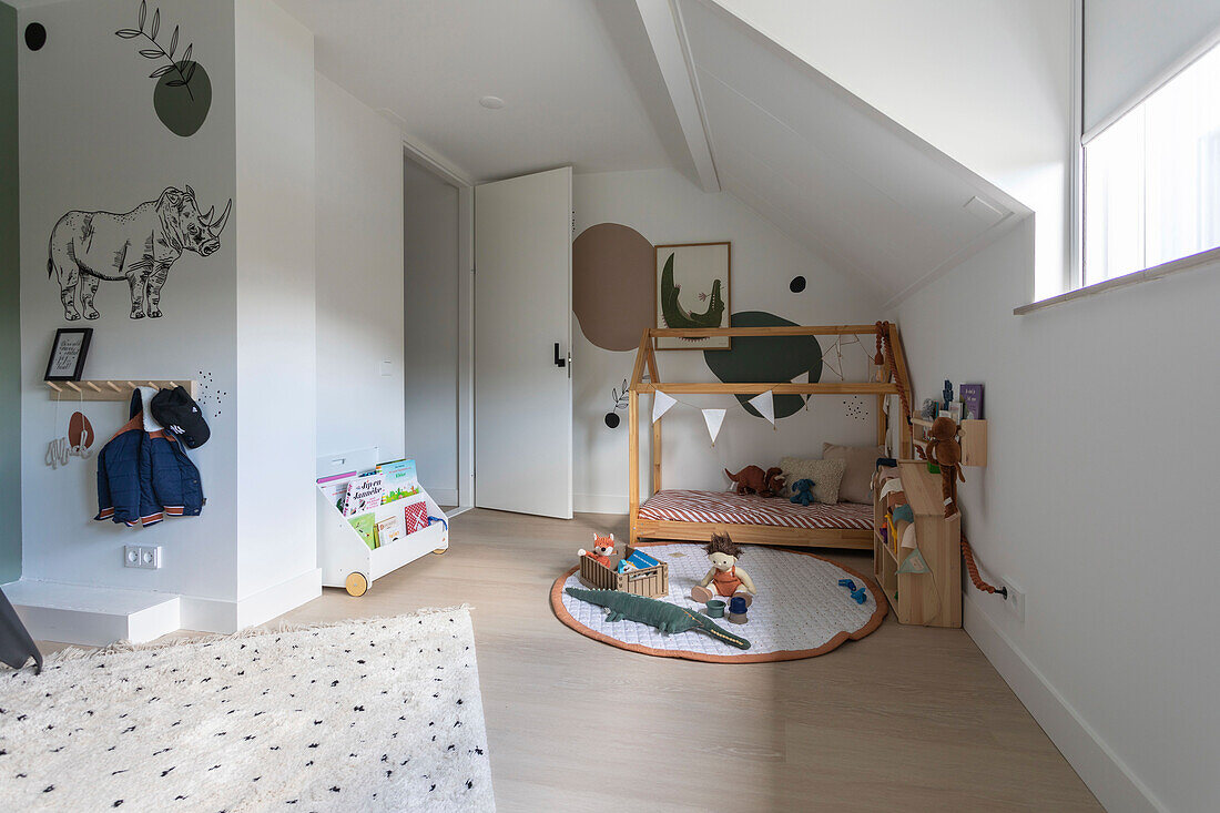 Children's room with house bed, wall decoration and toys